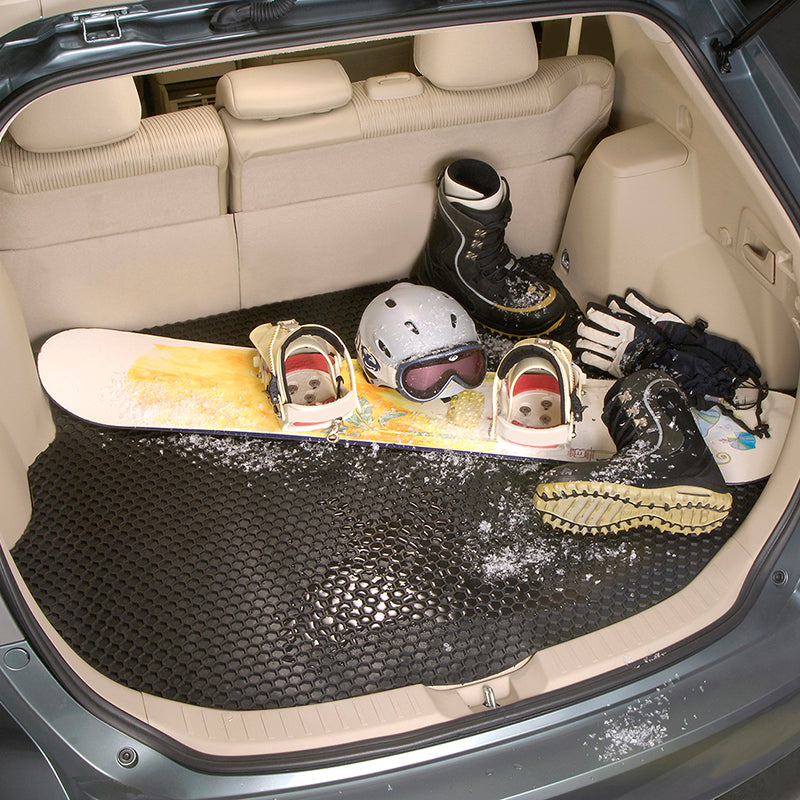 Black HexoMat cargo mat with a snowboard, helmet, and boots