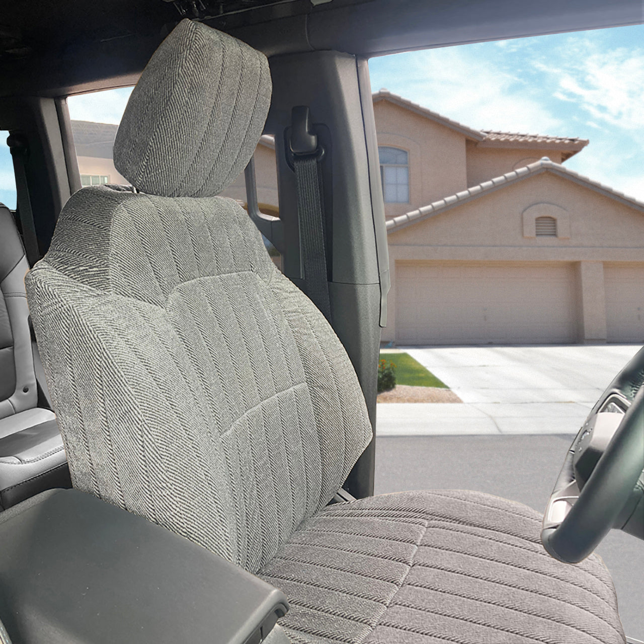 Seat Décor Madera Silver seat cover on a vehicle seat with a house and driveway in the background