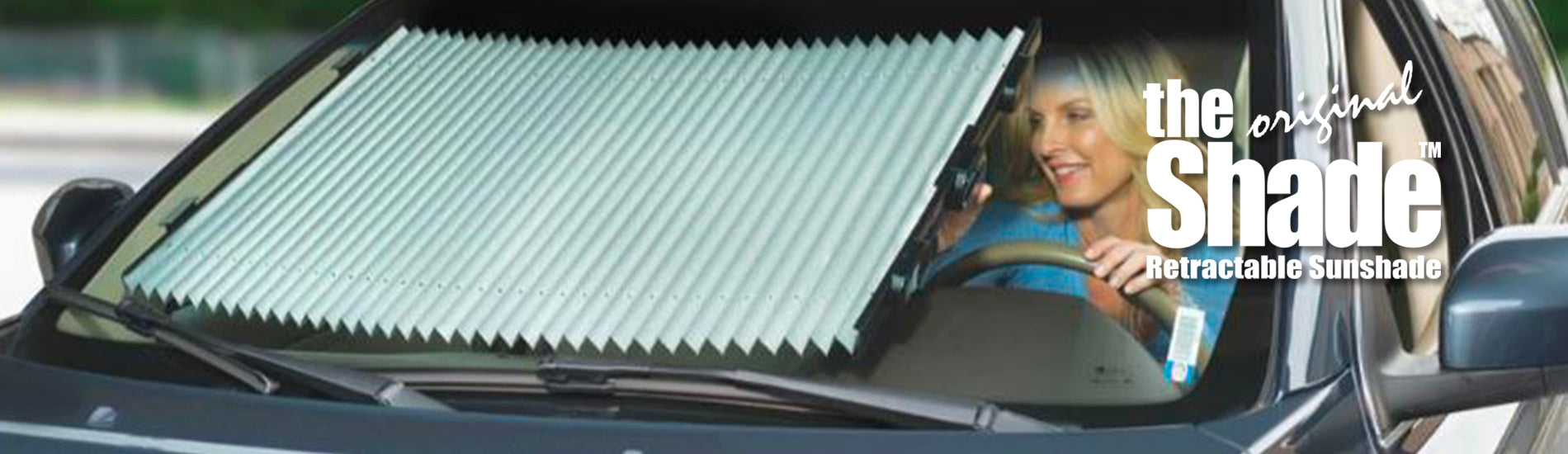 Retractable sunshade on a car window with a woman inside