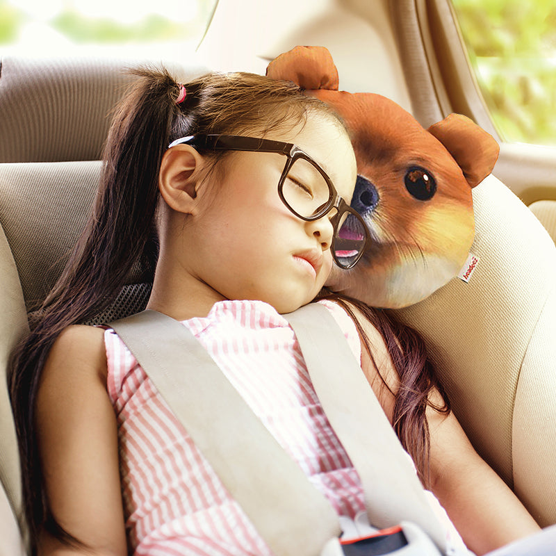 Little girl sleeping on a Pom Puppy Travel Pillow in a car