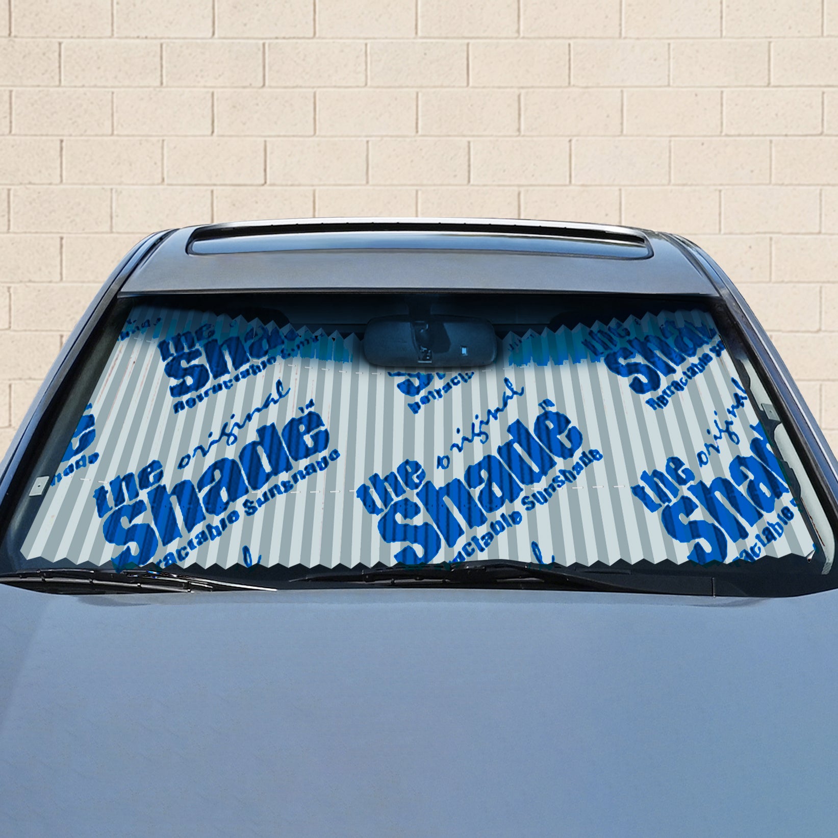 Retractable sunshade on a car window with Shade Logo branding.